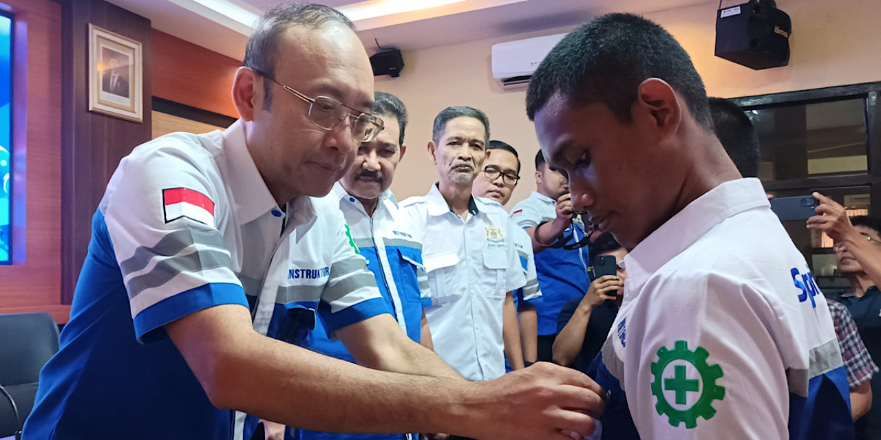 Direktur PT Indospring Tbk, Bob Budiono, menyematkan pin ke seragam siswa si acara launching program Spring School". (Foto: Sahlul Fahmi/jatimnow.com)