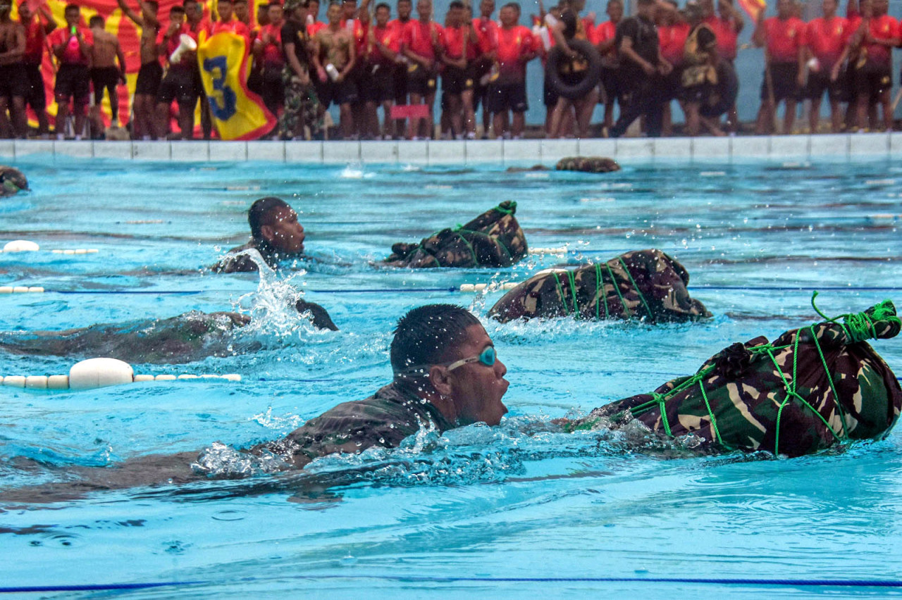 Prajurit Brigif 2 Marinir adu ketangkasan dalam lomba Renang Ponco 50 meter dengan perlengkapan tempur lengkap di Sidoarjo. (Foto: Ainul Yakin for JatimNow.com