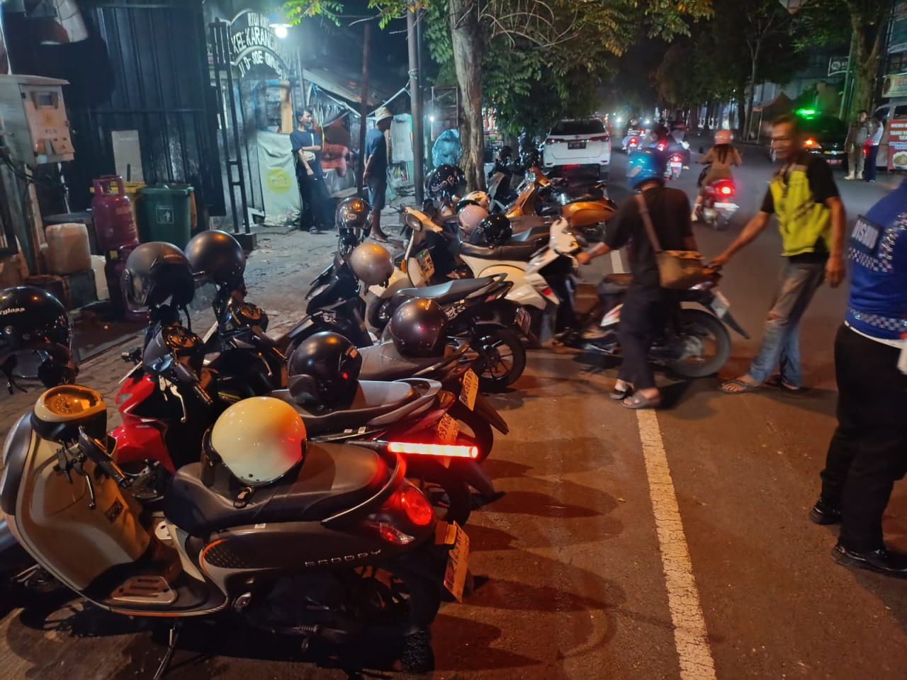 Foto: Jukir saat beraktifitas di salah satu ruas jalan di Tulungagung. (Bramanta/jatimnow.com)