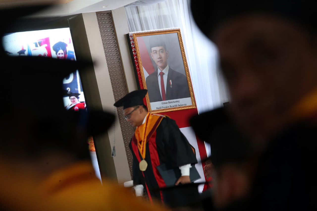 Foto Wakil Presiden Republik Indonesia, Gibran Rakabuming, terpampang di panggung prosesi Wisuda ke-132 Untag Surabaya pada Minggu (15/2/2026). Melalui penyelenggaraan Wisuda ke-132 ini, Untag Surabaya menegaskan komitmennya dalam mencetak lulusan yang tetap berakar pada identitas bangsa, sekaligus mampu memberikan kontribusi nyata bagi masyarakat dan dunia global. (Foto: Ali Masduki/jatimnow.com)