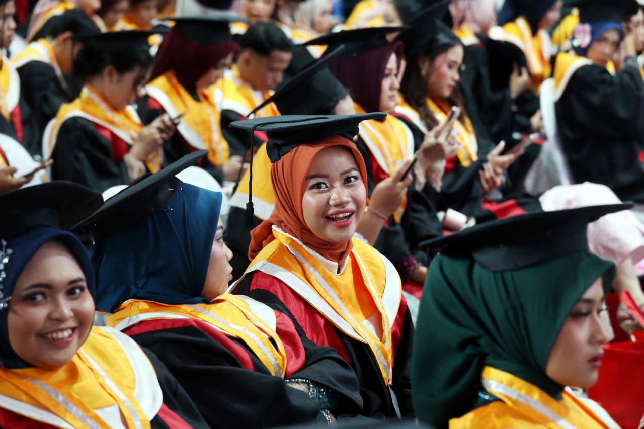 Wisudawati melempar senyum bahagia ketika mengikuti prosesi Wisuda ke-132 Untag Surabaya pada Minggu (15/2/2026). Wisuda ini menjadi momentum strategis bagi universitas dalam melepas 1.470 lulusan dari tujuh fakultas yang telah menyelesaikan pendidikan dan siap berkontribusi di tengah masyarakat maupun di tingkat global. (Foto: Ali Masduki/jatimnow.com)