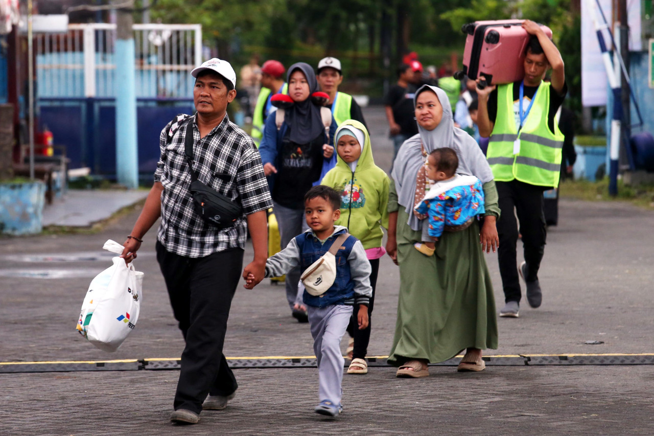 Pemudik bersama keluarga tiba di titik keberangkatan arus balik gratis Pertamina di Surabaya, Sabtu (28/3/2026). Program tersebut membantu warga kembali ke Jakarta tanpa biaya sekaligus mengurangi penggunaan kendaraan pribadi. (Foto: Ali Masduki/jatimnow.com).