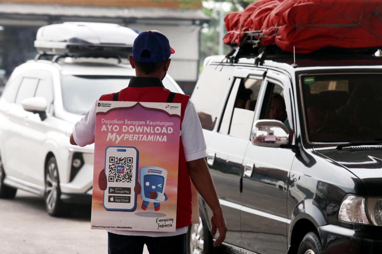 Petugas Pertamina Patra Niaga menawarkan penggunaan aplikasi MyPertamina kepada pengendara di area SPBU Rest Area 725 A Mojokerto, saat arus mudik Lebaran 2026 pada Kamis (19/3/2026). Program diskon BBM bagi transaksi nontunai digulirkan untuk mempercepat proses pengisian dan mengurangi antrean kendaraan. (Foto: Ali Masduki/JatimNow.com)