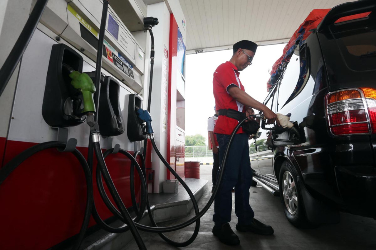 Petugas melayani pengisian BBM kendaraan pemudik di SPBU milik Pertamina saat arus mudik Lebaran 2026. Perusahaan mendorong penggunaan aplikasi MyPertamina guna mempercepat proses pembayaran sekaligus mengurangi antrean di area pengisian. (Foto: Ali Masduki/JatimNow.com)