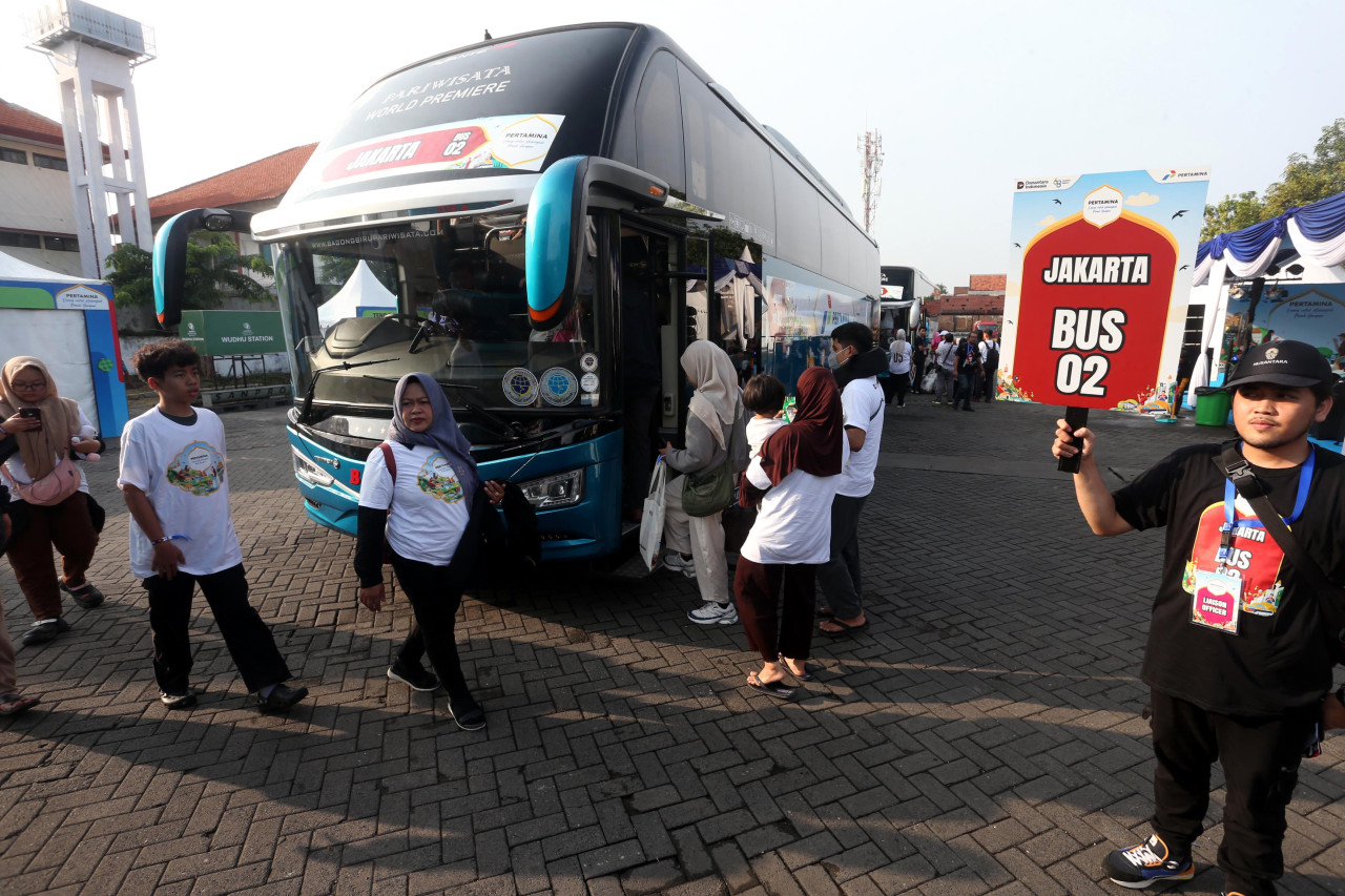 Petugas mengarahkan peserta arus balik gratis untuk naik ke bus tujuan Jakarta dalam program yang diselenggarakan Pertamina di Surabaya, Sabtu (28/3/2026). Layanan ini memudahkan pemudik kembali ke ibu kota tanpa biaya sekaligus membantu mengurangi kepadatan lalu lintas selama arus balik Lebaran. (Foto: Ali Masduki/jatimnow.com).