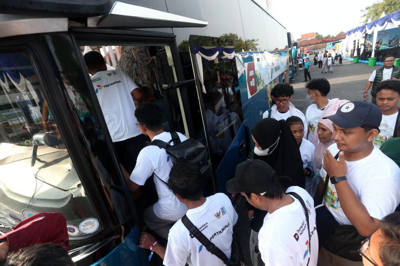 Sejumlah pemudik antre naik bus dalam program arus balik gratis yang diselenggarakan Pertamina di Surabaya, Sabtu (28/3/2026). Program ini memfasilitasi warga kembali ke Jakarta tanpa biaya sekaligus membantu mengurangi kepadatan lalu lintas selama periode arus balik Lebaran. (Foto: Ali Masduki/jatimnow.com).