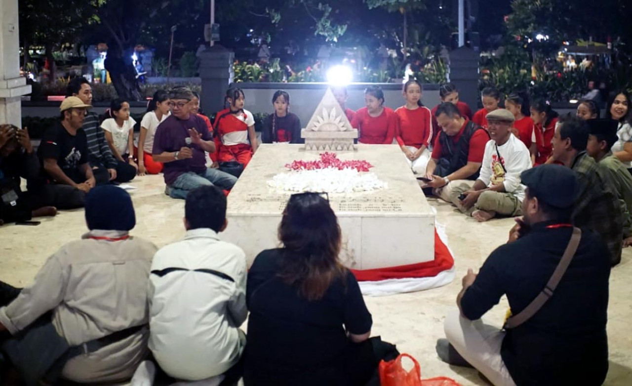 Puluhan seniman dan pegiat budaya doa bersama di pusara makam WR Supratman Surabaya. (Foto: Julian for JatimNow.com)