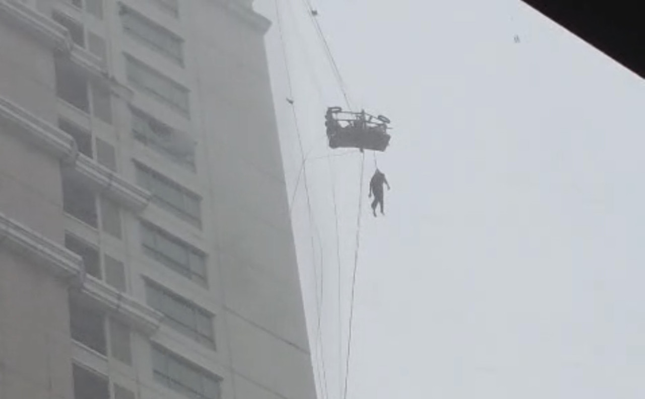 Satu petugas tergelantung di gondola Kawasan Pakuwon Indah (tangkapan layar)
