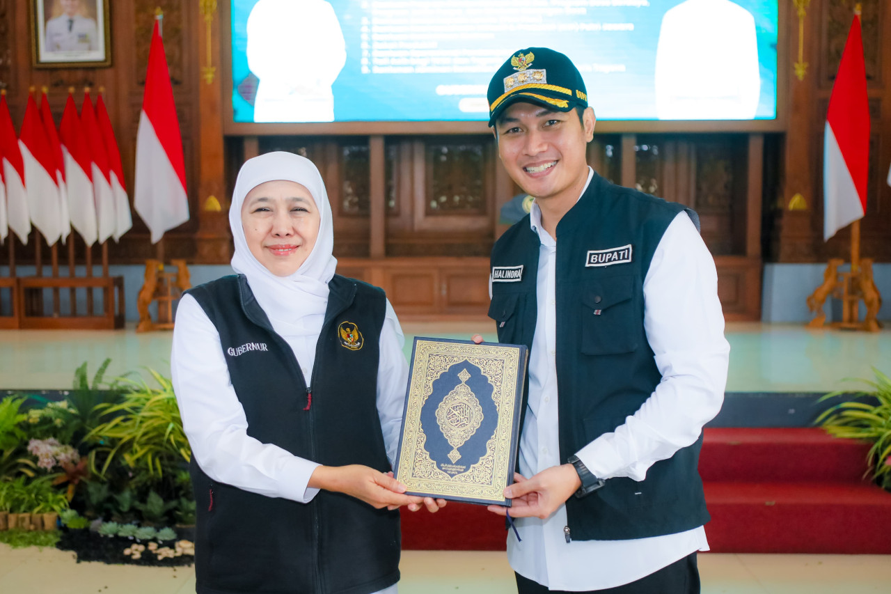 Khofifah (kiri) saat menyerahkan mushaf Alquran dari Kerajaan Arab Saudi pada Bupati Tuban Halindra (kanan) (foto: Adpim for jatimnow.com)