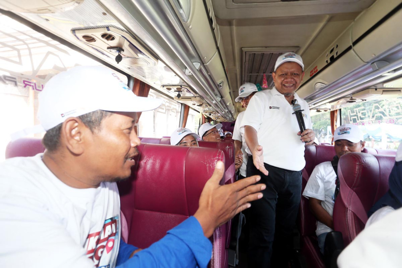 Region Head PTPN I Regional 5, Subagiyo, menyapa pemudik di dalam bus saat pemberangkatan program mudik gratis dari Surabaya, Senin (17/3). Sebanyak 600 peserta diberangkatkan ke berbagai kota di Pulau Jawa. (Foto: Ali Masduki/jatimnow.com)
