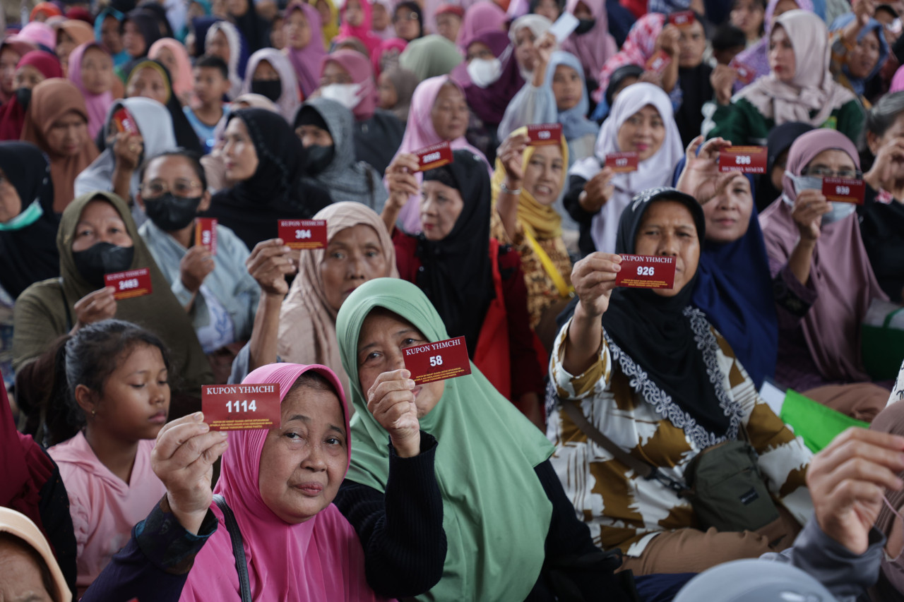 Wajah gembira ibu dan lansia saat memperlihatkan kupon pengambilan zakat di Halaman Masjid Cheng Hoo (foto: Humas Pemkot Surabaya for for jatimnow.com)