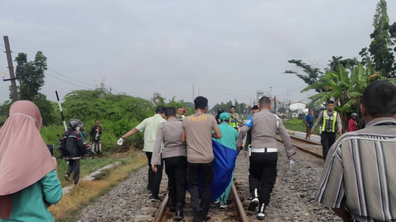 Proses evakuasi Mr. X tertabrak KA di Lamongan oleh petugas kepolisian. (Foto: Adyad Ammy Iffansah/jatimnow.com)