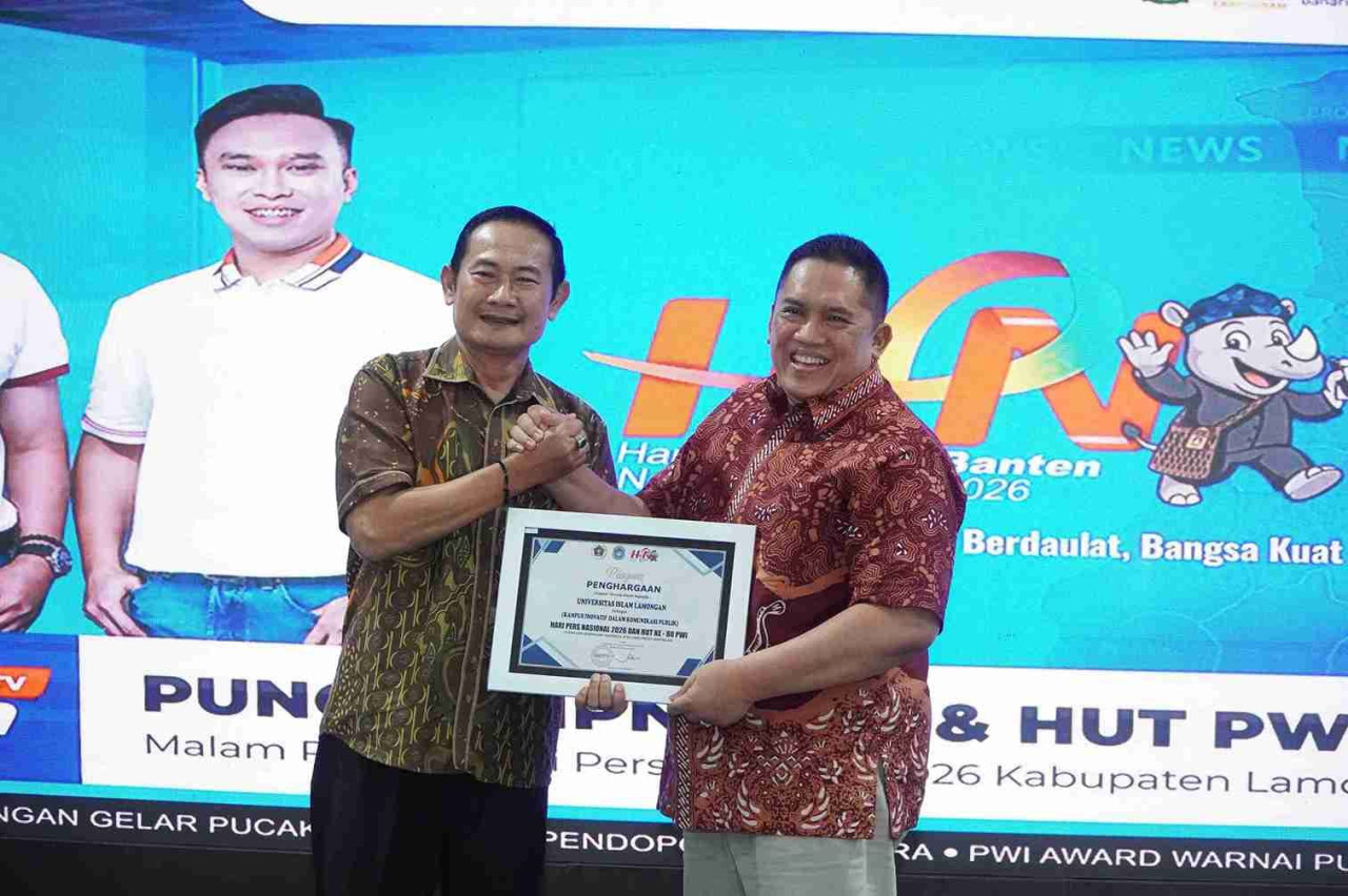 Rektor Unisla, Abdul Ghofur saat menerima penghargaan kampus inovatif komunikasi publik dari Bupati Lamongan dalam anugerah PWI Lamongan HPN 2026. (Foto : Adyad Ammy Iffansah/jatimnow.com)