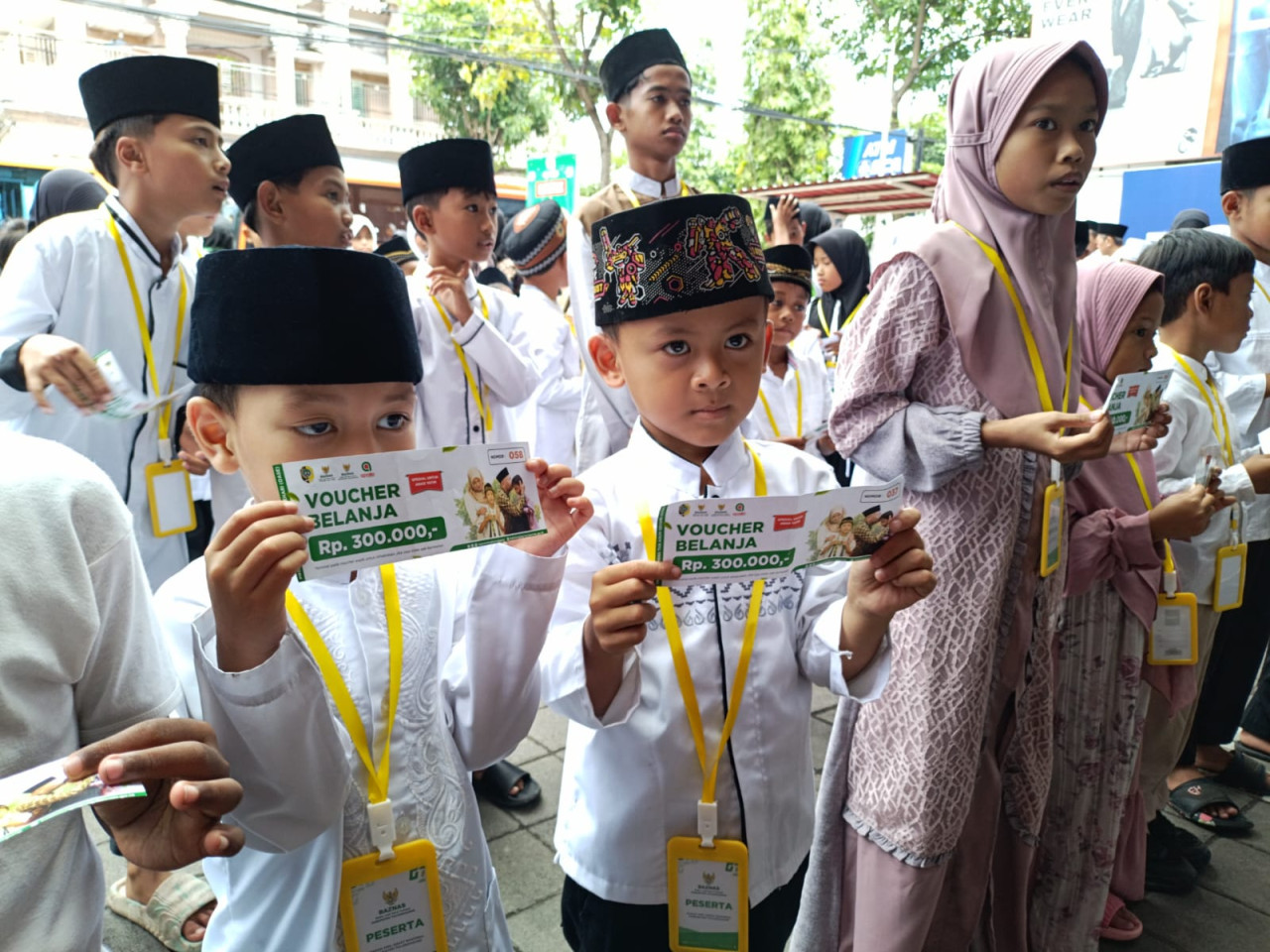 Foto: Anak yatim piatu di Tulungagung menunjukkan voucer belanja. (Bramanta/jatimnow.com)