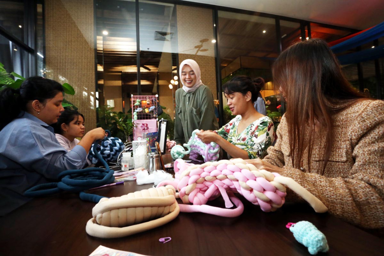 Nadia Putri Nilamsari (tengah) memandu peserta yang mengikuti workshop Chunky Bag di EXCOTEL Surabaya, Minggu (8/3/2026). (Foto: Ali Masduki/jatimnow.com)