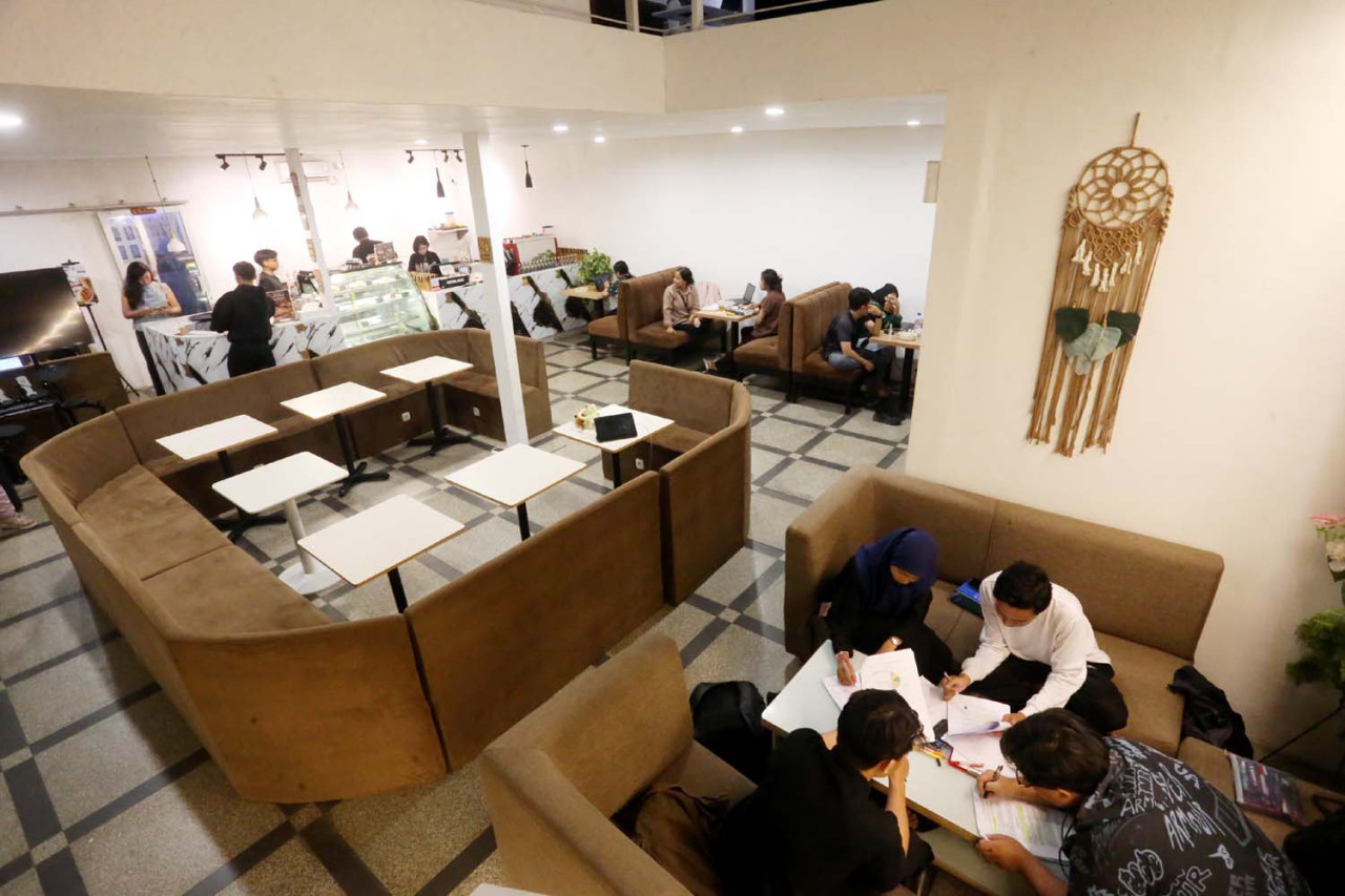 Aktivitas pengunjung di Hanaka Social Space menunjukkan fungsi ruang yang fleksibel, dari tempat nugas dan diskusi hingga nongkrong santai dalam satu suasana yang tetap nyaman dan hidup.(Foto: Ali Masduki/jatimnow.com)