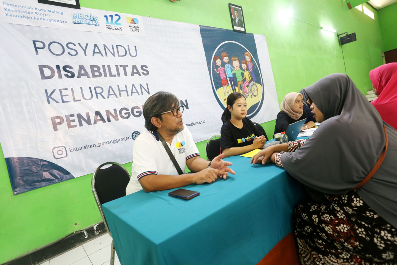 Founder MAC, Mohammad Cahyadi bersama tim memberikan asesmen kepada warga dalam kegiatan Posyandu Disabilitas di Kelurahan Penanggungan, Kota Malang. Layanan ini mencakup pemeriksaan kesehatan dan pemetaan kebutuhan terapi bagi penyandang disabilitas. (Ali Masduki/jatimnow.com)