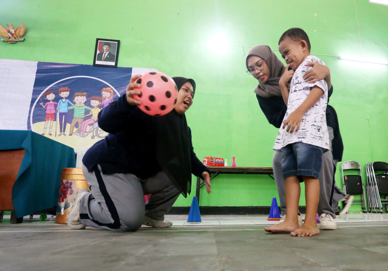 Terapis MAC melatih kemampuan motorik anak dalam kegiatan Posyandu Disabilitas di Kelurahan Penanggungan, Kota Malang. Pendampingan dilakukan melalui permainan untuk membantu perkembangan fisik dan kepercayaan diri anak. (Ali Masduki/jatimnow.com)