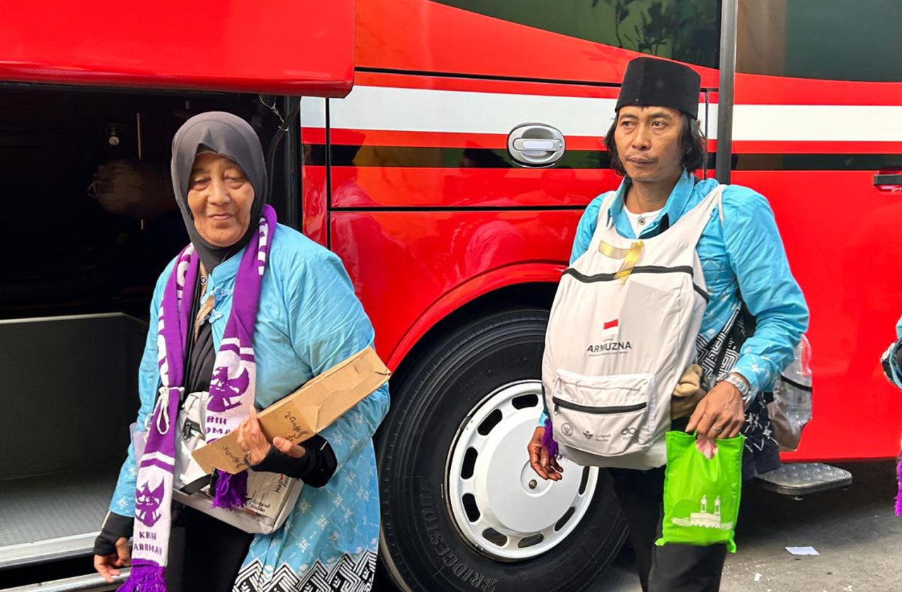 Didik “Seket” (kanan), bersiap berangkat ke Tanah Suci bersama ibundanya dari Asrama Haji Embarkasi Surabaya, Kamis (23/4/2026). (Foto: Lely for jatimnow.com)