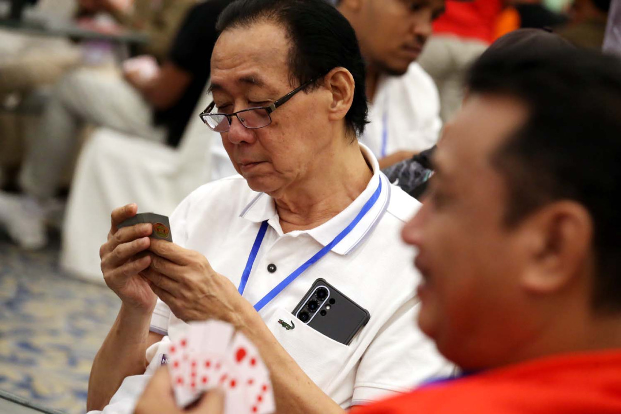 Seorang peserta fokus membaca kartu saat bertanding dalam Surabaya Domino Tournament 2026 di Grand City Convention Hall. Kompetisi ini menuntut ketelitian, strategi, dan konsentrasi tinggi di tengah ketatnya persaingan antar peserta dari berbagai daerah. (Foto: Ali Masduki/jatimnow.com)