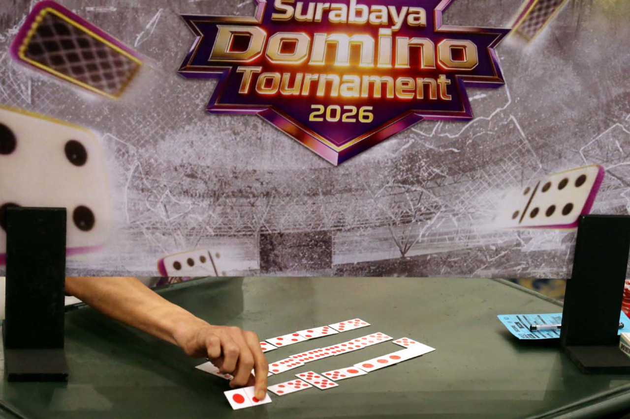 Tangan peserta menempatkan kartu di meja pertandingan Surabaya Domino Tournament 2026 di Grand City Convention Hall. Setiap langkah jadi penentu, menguji ketajaman strategi dan perhitungan dalam persaingan ketat antar atlet domino nasional. (Foto: Ali Masduki/jatimnow.com)