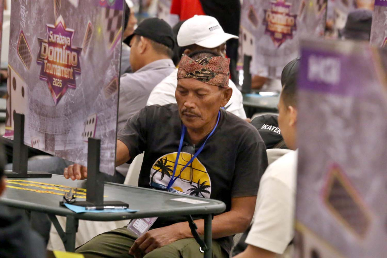 Seorang peserta fokus menyusun langkah saat bertanding di ajang Surabaya Domino Tournament 2026 yang digelar di Grand City Surabaya, Sabtu (18/4/2026). Turnamen ini diikuti ratusan atlet dari berbagai daerah dan menjadi momentum penguatan citra domino sebagai olahraga berbasis strategi dan kecerdasan.(Foto: Ali Masduki/jatimnow.com)