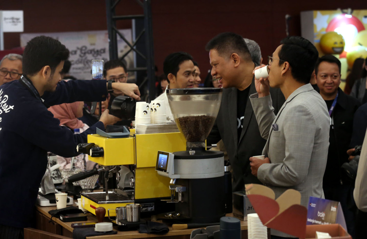 Pengunjung menikmati sajian kopi dari tenant peserta saat pembukaan Indonesia Coffee Expo (ICX) 2026 di Grand City Convention Hall Surabaya, Jumat (29/5/2026). Pameran tersebut menjadi pembuka rangkaian roadshow nasional ICX sekaligus mempertemukan pelaku industri kopi, komunitas kreatif, dan pecinta kopi dalam satu ajang interaktif. (Foto: Ali Masduki/jatimnow.com)