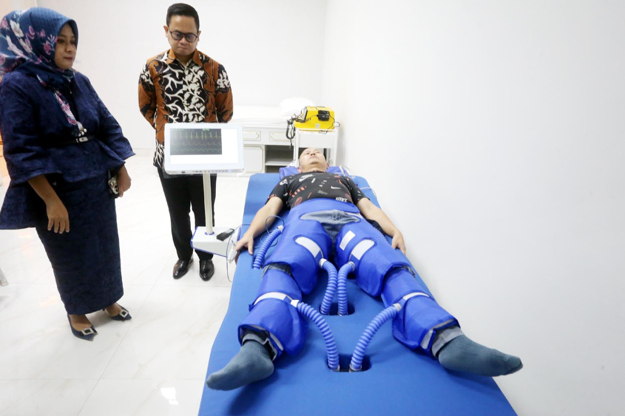 Demonstrasi pasien rehabilitasi jantung, sedang menjalani terapi Enhanced External Counterpulsation (EECP) di Pramita Ngagel, Surabaya. Alat EECP ini membantu meningkatkan kapasitas jantung dengan cara memberikan kompresi pada tungkai kaki pasien. (Foto: Ali Masduki/jatimnow.com)