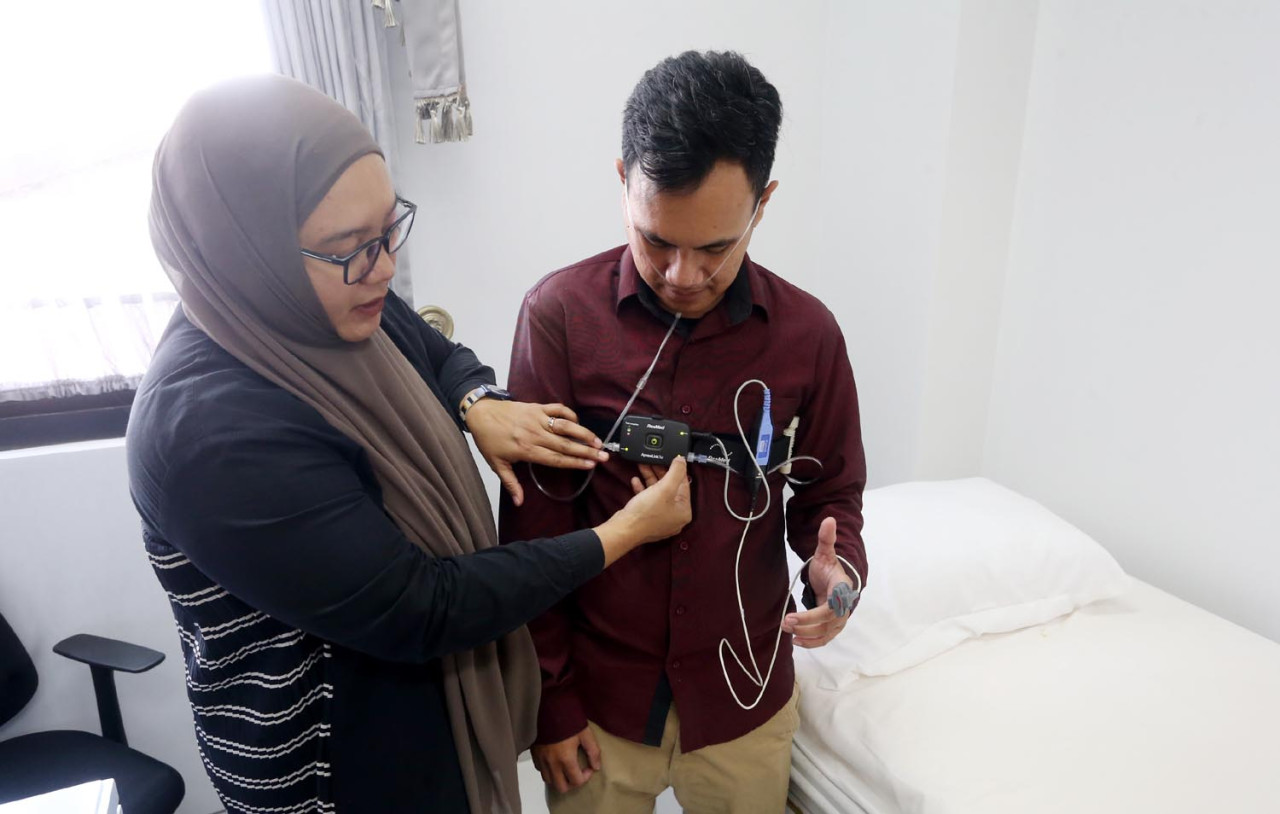 Sleep Technician sekaligus Direktur Resindo Medica, Andini Ekawati, memperagakan penggunaan alat Apnea Link di Pramita Ngagel, Surabaya, Sabtu (16/5/2025). (Ali Masduki/jatimnow.com)