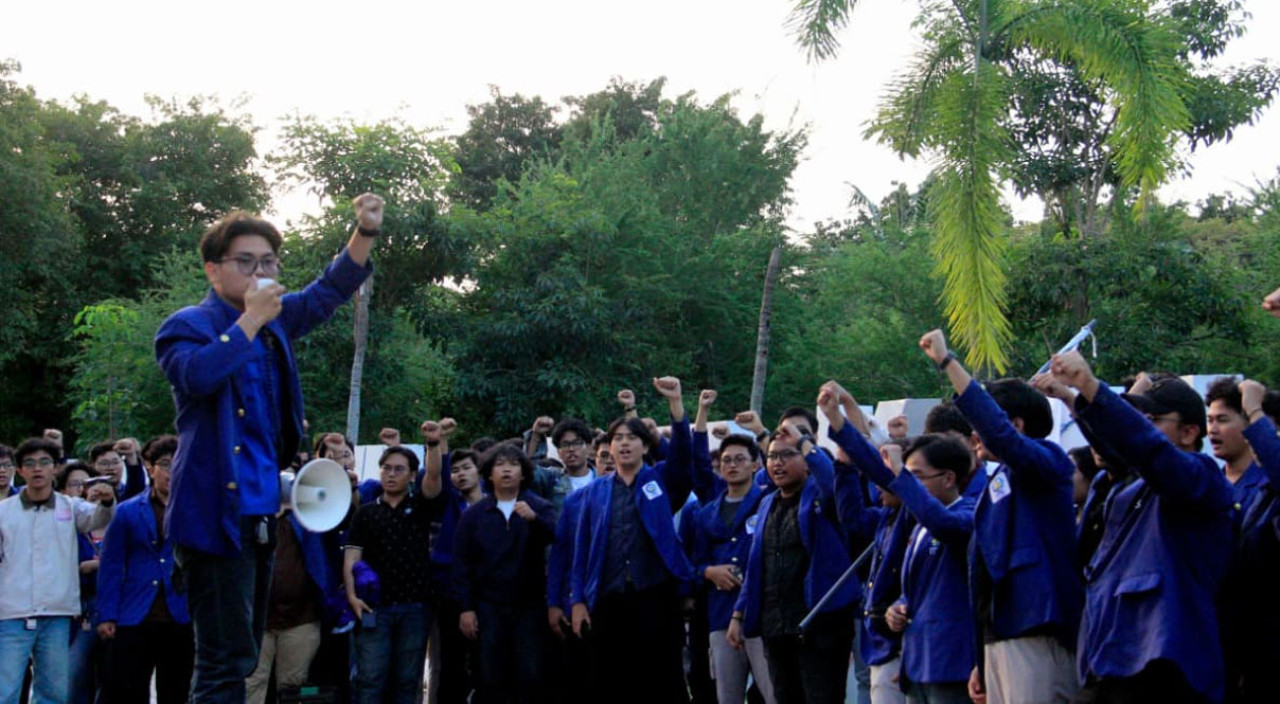 Puluhan mahasiswa ITS mengepalkan tangan bersama orator untuk menyuarakan aspirasi terhadap isu kebijakan pemerintah dalam aksi mimbar bebas di Bundaran ITS. (Foto: Humas ITS for jatimnow.com)