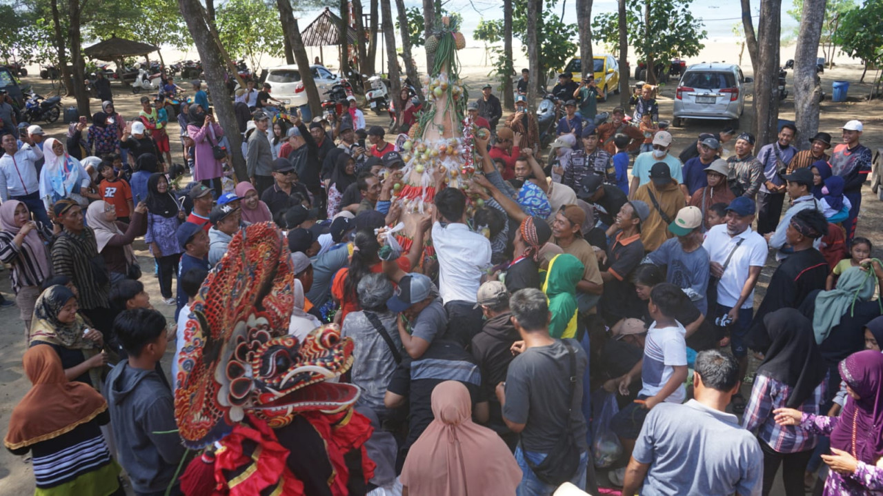 Warga dan wisatawan berebut tumpeng dalam grebeg suro di Pantai Gemah Tulungagung. (Foto: Bramanta/jatimnow.com)