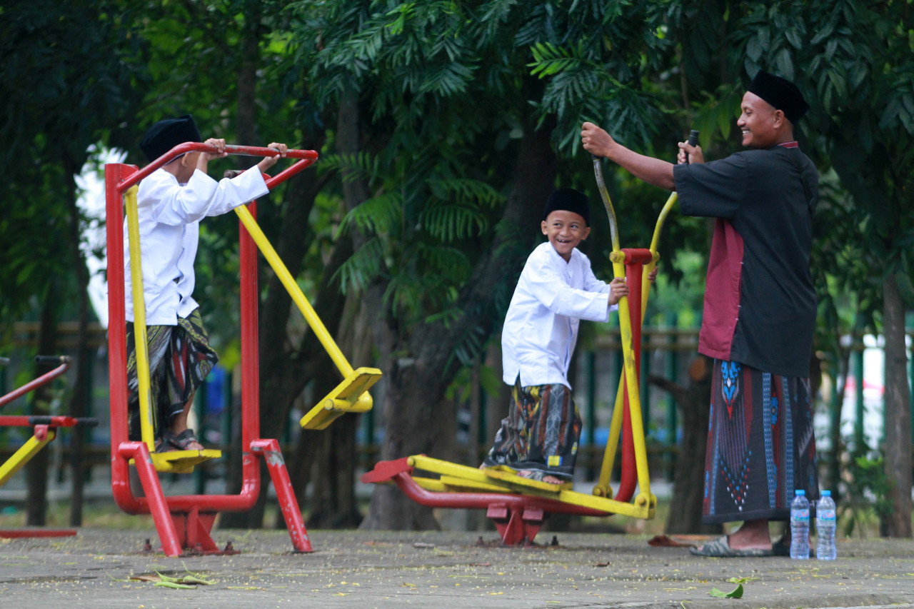 Ainur Rofiq saat mengajak bermain putra kembarnya Dalfa dan Dalfi yang berusia 7 tahun di halaman GOR Tridharma Petrokimia Gresik. (Foto: Sahlul Fahmi/jatimnow.com)