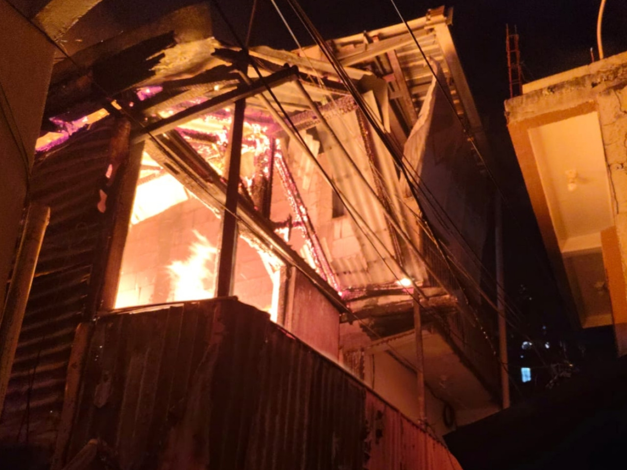 Rumah dua lantai yang terbakar pada Selasa (30/6/2026) malam. (Foto: Dinas Pemadam Kebakaran Surabaya for jatimnow.com)