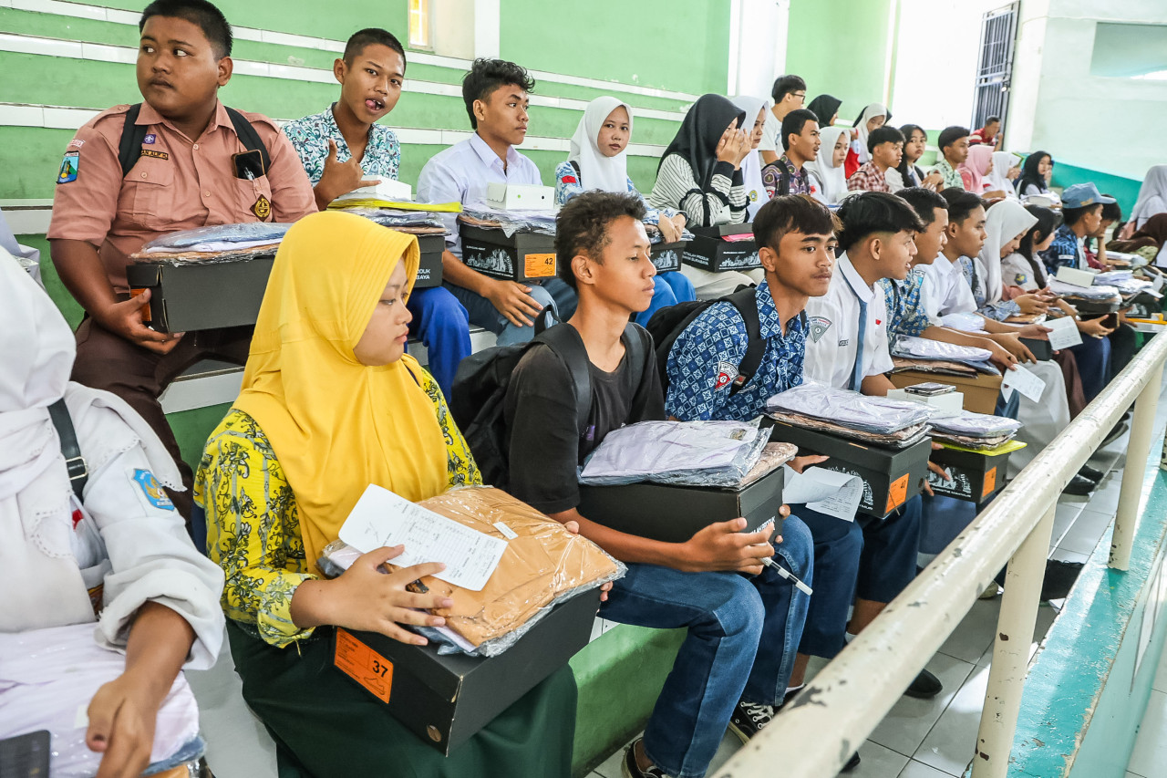 Sejumlah siswa menerima bantuan seragam dari Pemkot Surabaya