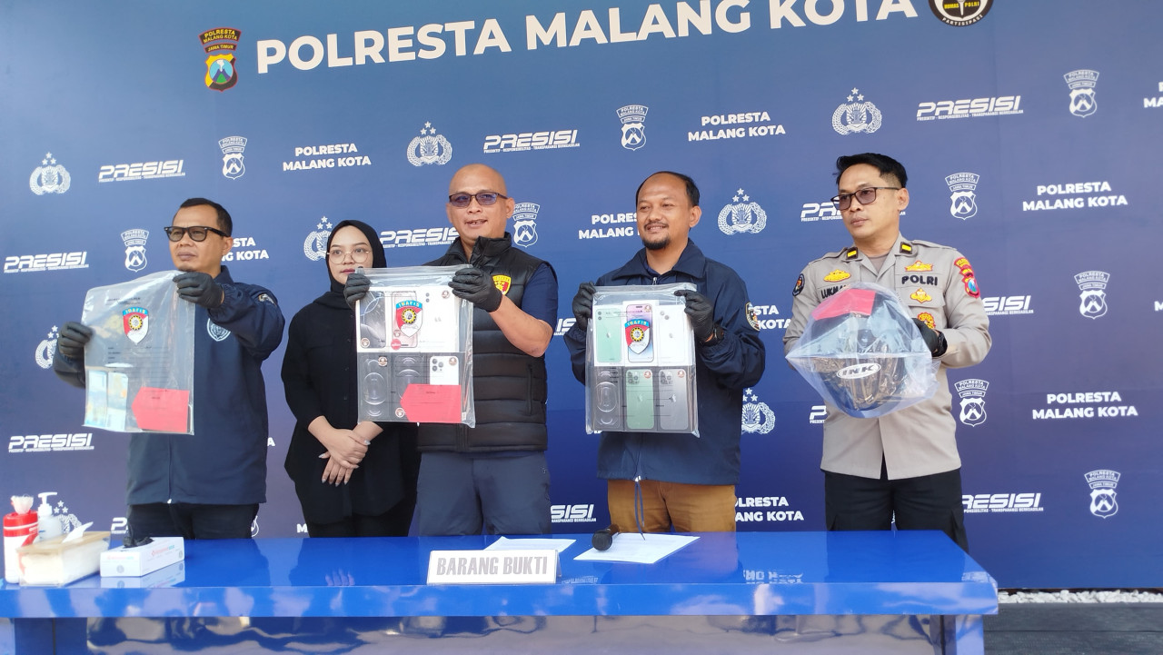 Polisi menunjukkan barang bukti berupa unit iPhone dan uang yang disita dari tersangka (Foto: Aris/ jatimnow.com)