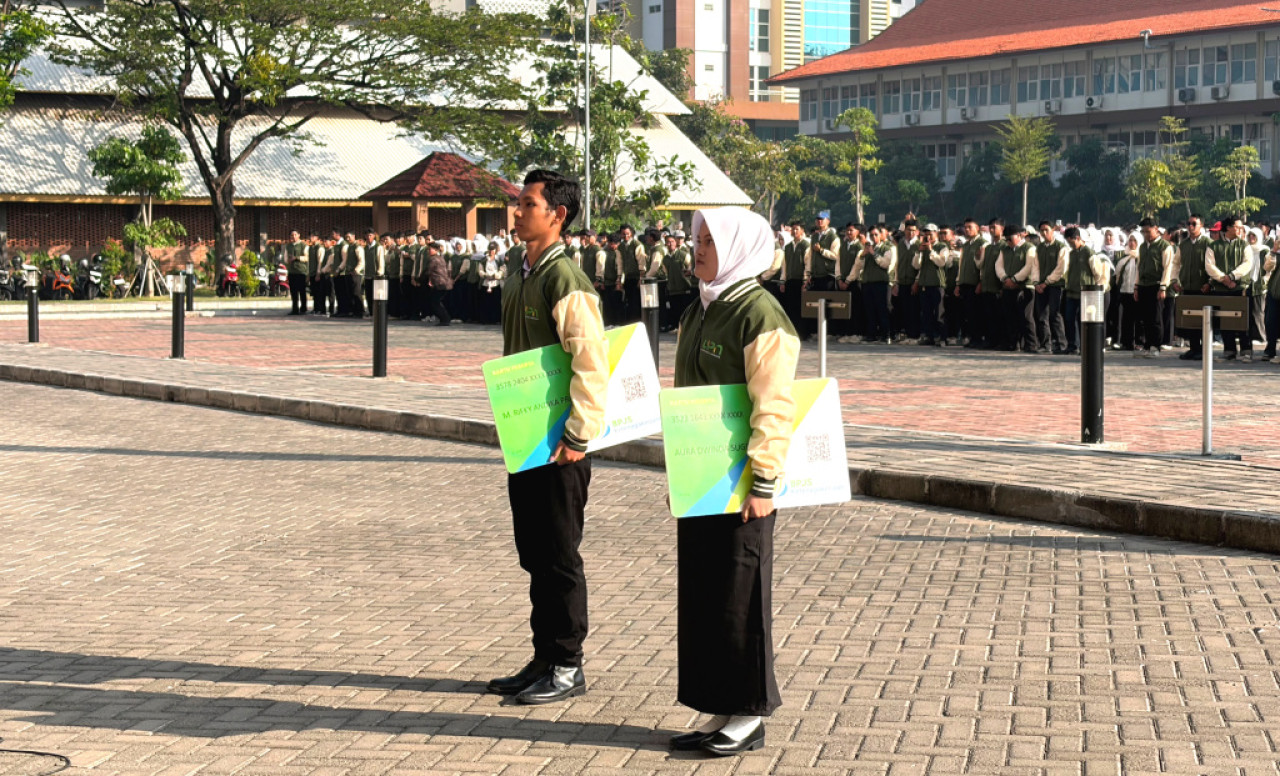 Penyerahan simbolis kartu kepesertaan dilakukan saat pelepasan mahasiswa KKN di Lapangan UPN Veteran Jawa Timur, Kamis (10/7). (Foto/jatimnow.com)