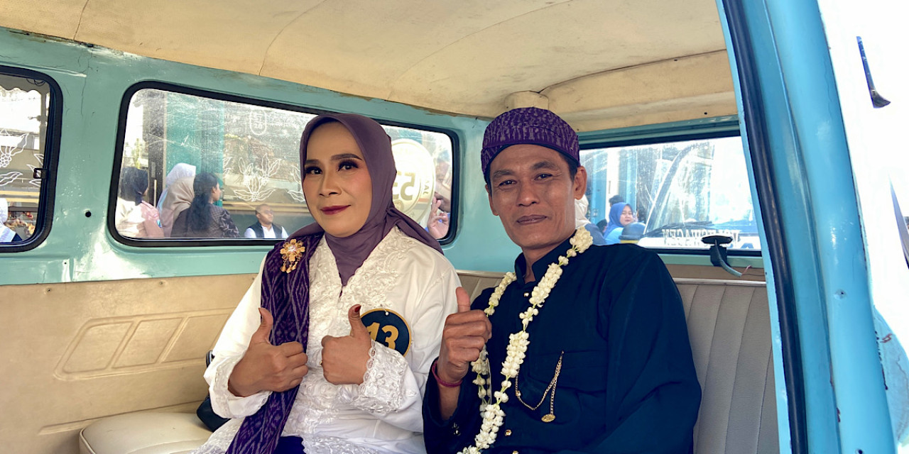 Pasangan nikah massal di Kota Kediri berpose di dalam VW Kombi. Mereka tampak bahagia dengan pernikahan yang seluruh biayanya ditanggung Pemerintah Kota Kediri.