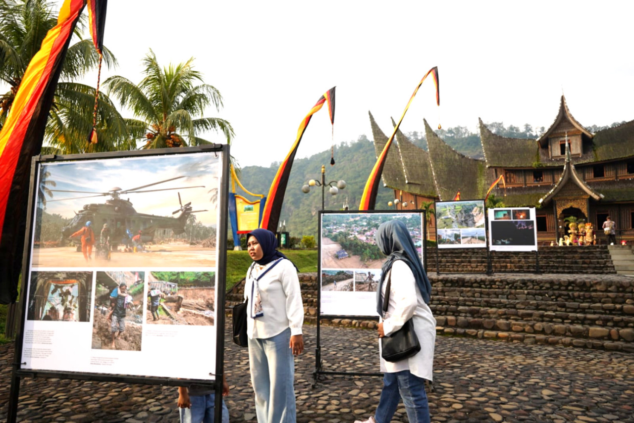 Pengunjung mengamati pameran foto jurnalistik Prahara Pulau Emas di Istano Basa Pagaruyung, Kabupaten Tanah Datar, Sumatera Barat, Senin (27/7/2026). (Foto/PFI Padang)