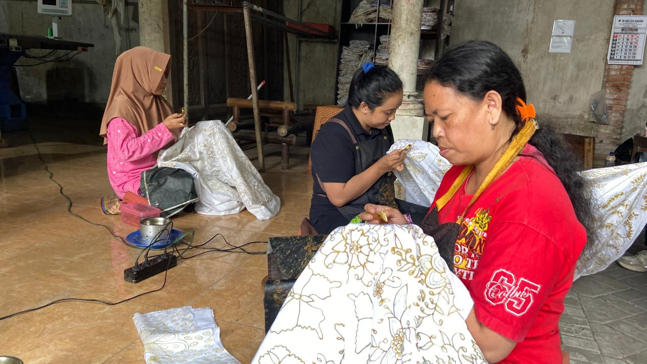 Fitri (kanan) dan Pita (tengah) sedang fokus membatik di ruang kerja Batik Tulis Olive. Mistiah (kiri), pembatik asal Pamekasan adalah guru bagi mereka.