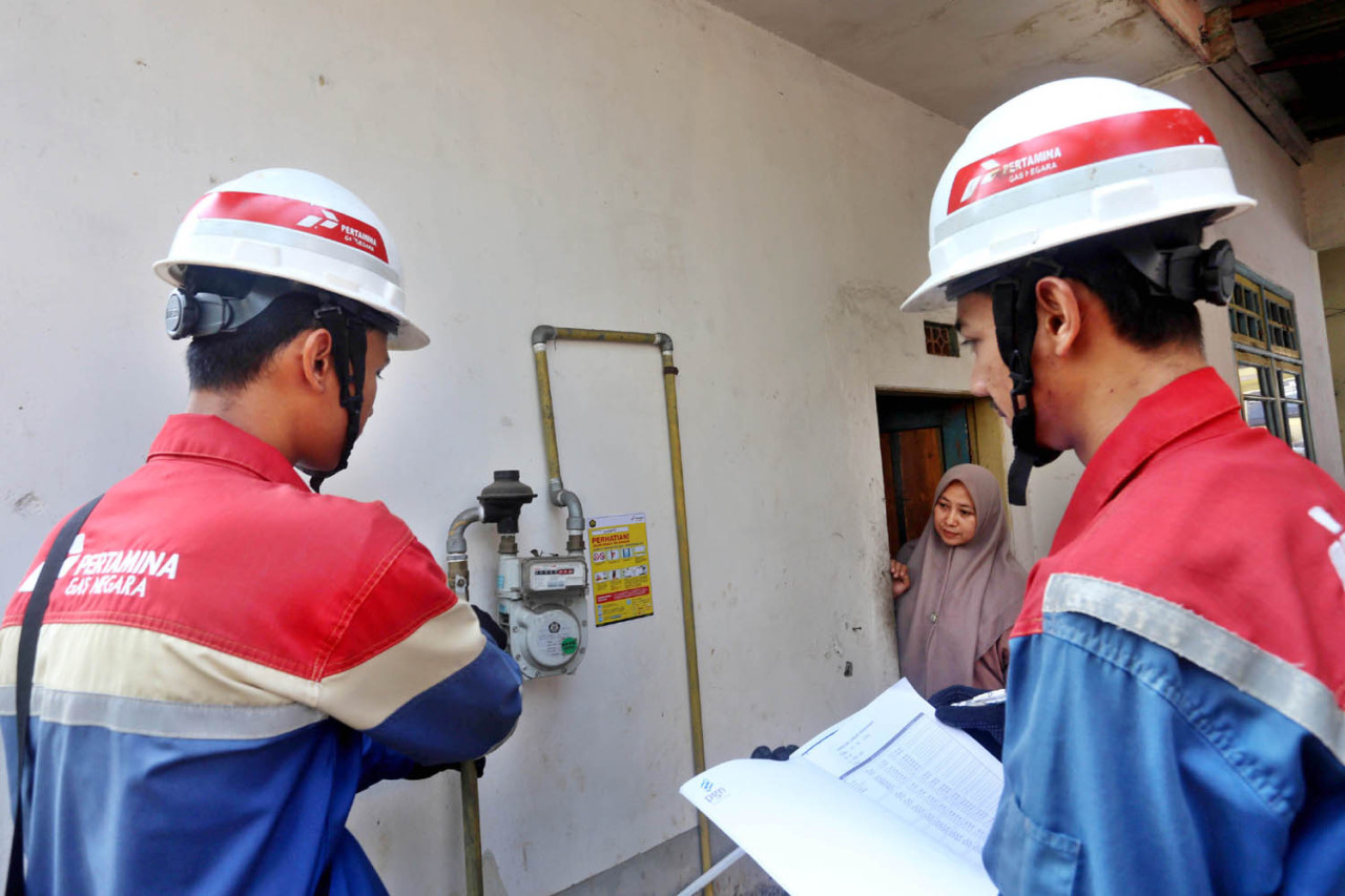 Dua petugas PT Perusahaan Gas Negara (PGN) melakukan pemeriksaan meter dan regulator di rumah Ernawati, pelanggan Jargas PGN di Kabupaten Lumajang, Senin (03/8/2026). Pengecekan ini guna memastikan distribusi gas berlangsung aman sesuai standar operasional. (Foto: Ali Masduki/jatimnow.com)