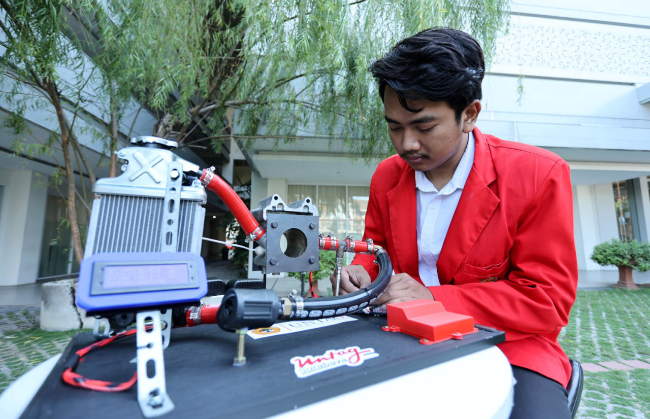 Mahasiswa Program Studi Teknik Elektro Untag Surabaya, Fendy Febianto Ahmad, mendemonstrasikan prototipe sistem monitoring suhu motor dengan tiga sensor. (Foto: Humas Untag Surabaya for jatimnow.com)