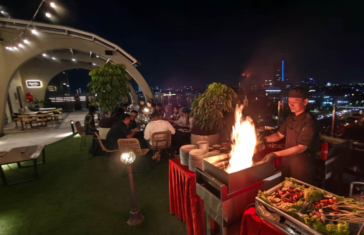 Momen Chef mendemokan serunya live grilling di rooftop EXCOTEL Surabaya, Jumat (07/8/2026). (Foto: Ali Masduki/jatimnow.com)