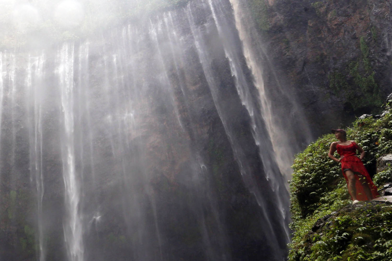 Wisatawan berpose menikmati keidahan panorama Air Terjun Tumpak Sewu di Kabupaten Lumajang, Jawa Timur. (Foto: Ali Masduki/jatimnow.com)