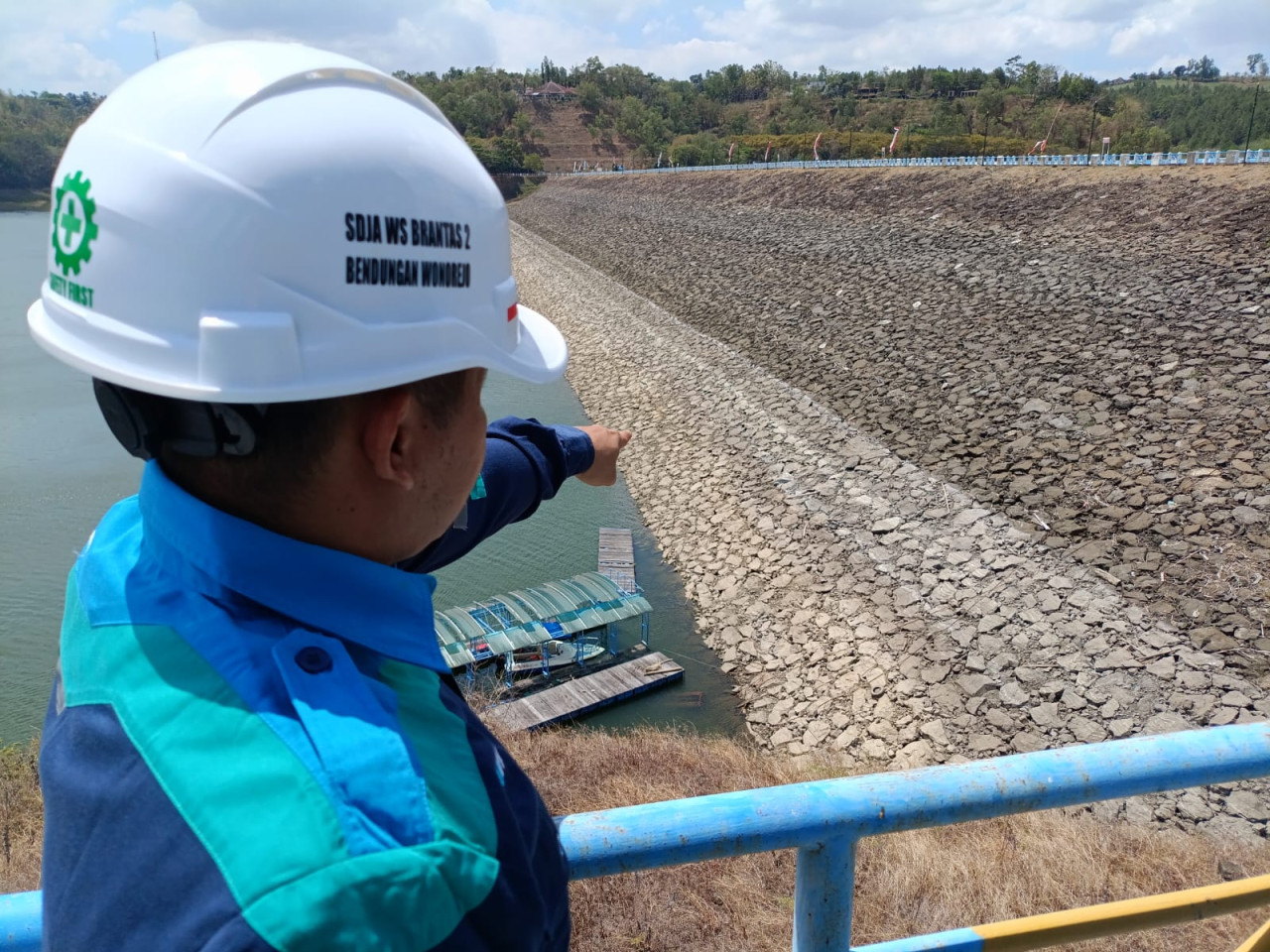 Petugas memperlihatkan susutnya permukaan air di Waduk Wonorejo Tulungagung. (Foto: Bramanta/jatimnow.com)
