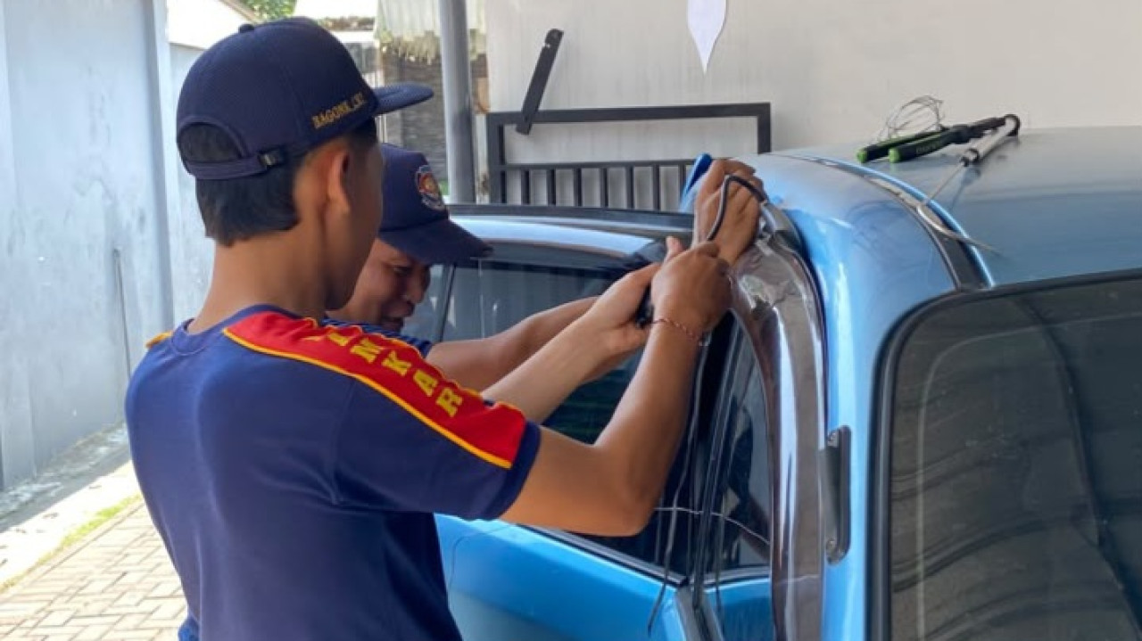 Petugas Pemadam Kebakaran (Damkar) Kabupaten Kediri mengevakuasi anak terkunci di mobil. (Foto: Damkar Kediri/jatimnow.com)
