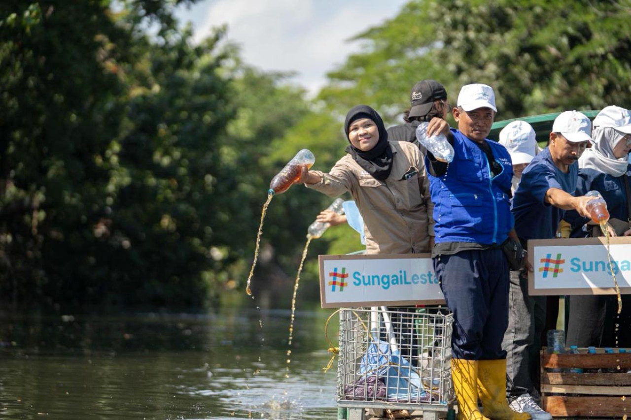 Penuangan 300 liter eco enzyme, cairan fermentasi sampah organik, oleh Komunitas Relawan Eco Enzyme Nusantara Cabang Surabaya untuk memperbaiki kualitas air. (Foto: Ecoton for jatimnow.com)