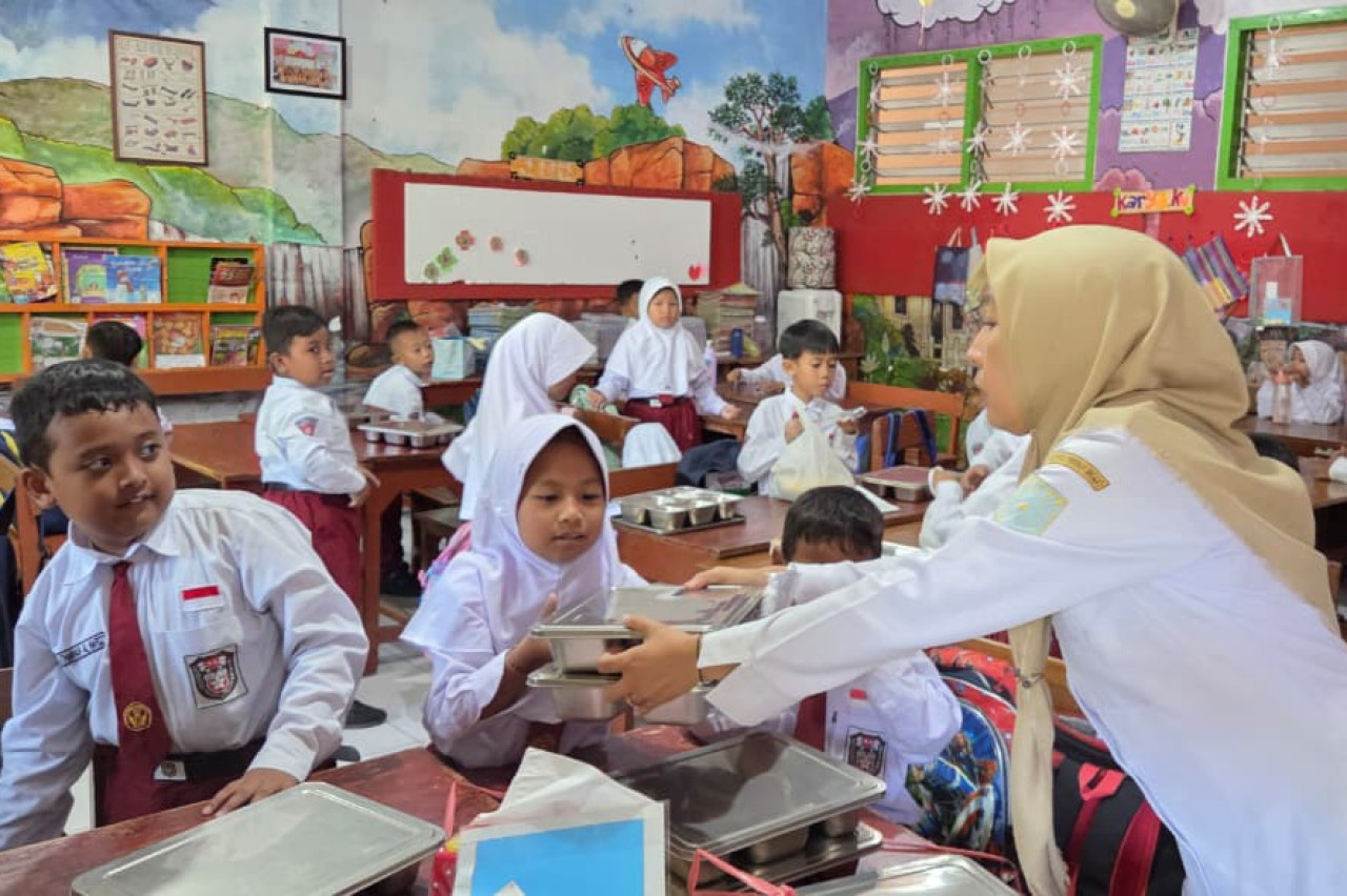 Petugas membagikan MBG ke siswa di Kota Probolinggo. (Foto: Ide Farid/jatimnow.com)