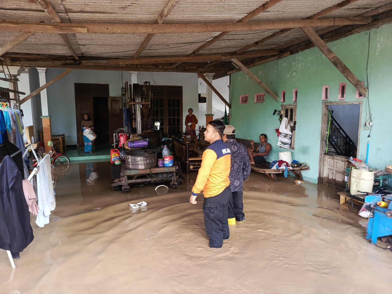 Petugas saat berada di salah satu rumah warga yang terendam luapan sungai. (Foto: BPBD Tulungagung for jatimnow.com)