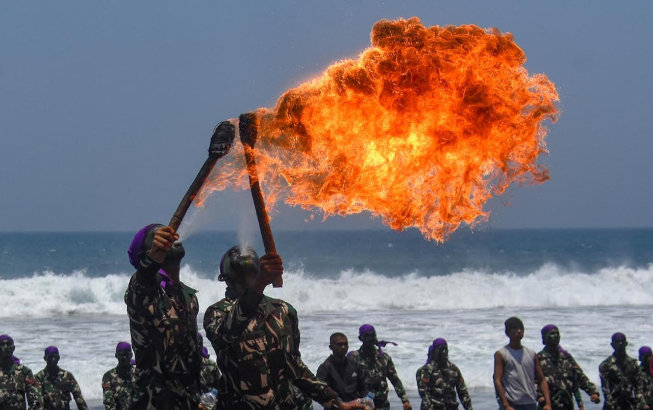  Prajurit Korps Marinir TNI AL menunjukkan atraksi sembur api disela Upacara Pembaretan Mantan Siswa Komando Angkatan ke-180 di Pantai Baruna, Malang Selatan, Jawa Timur, Senin (12/10).(Foto: Ainul Yakin for jatimnow.com)