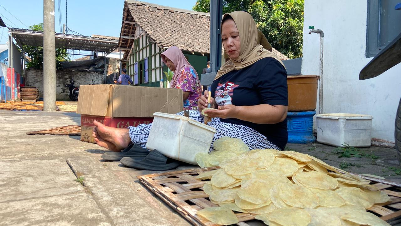 Suasana di salah satu rumah produksi milik Maimunah di Kampung Emping Belinjo, Kecamatan Pare, Kabupaten Kediri, Kamis (8/10/2026). Di kampung yang relatif kecil itu, para pekerja melakukan berbagai aktivitas, mulai dari menambahkan rasa pada emping, menjemur, hingga mengemasnya. (Foto: Yanuar Dedy/jatimnow.com)